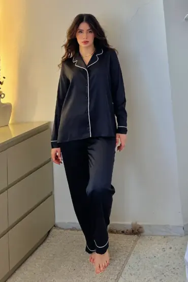 Pyjama satin noir élégant avec poignets et col contrastants, idéal pour une tenue d'intérieur chic et confortable.