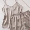 Pyjama satin beige élégant, comprenant un débardeur et un short, parfait pour une tenue d'intérieur confortable.