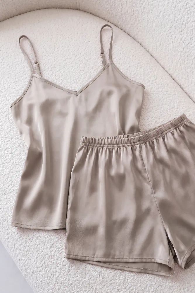 Pyjama satin beige élégant, comprenant un débardeur et un short, parfait pour une tenue d'intérieur confortable.