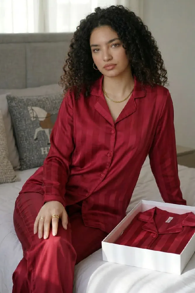 Pyjama satin rouge à rayures, élégant et confortable, idéal pour une tenue d'intérieur sophistiquée et chaleureuse.