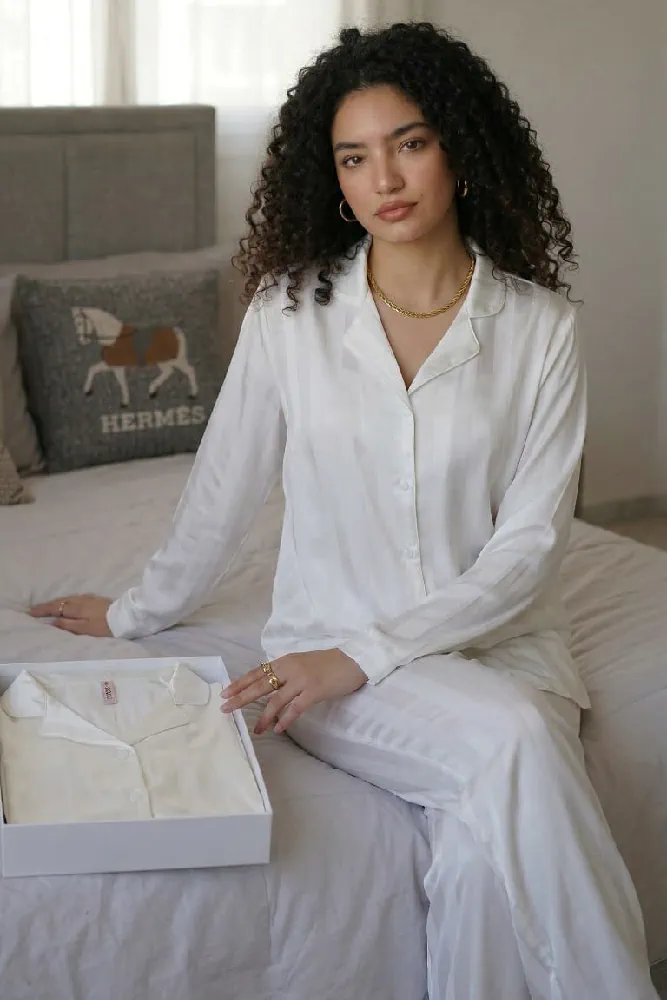 Pyjama satin blanc élégant avec une coupe chic, idéal pour une tenue d'intérieur confortable et raffinée.