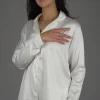 Pyjama satin blanc élégant, manches longues, idéal comme tenue d'intérieur confortable.