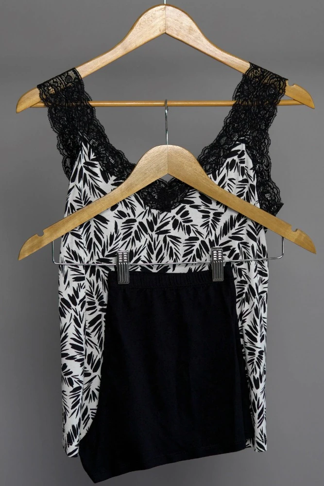 Débardeur noir à motifs blanc en dentelle sophistiquée, parfait pour un vêtement de nuit luxueux.