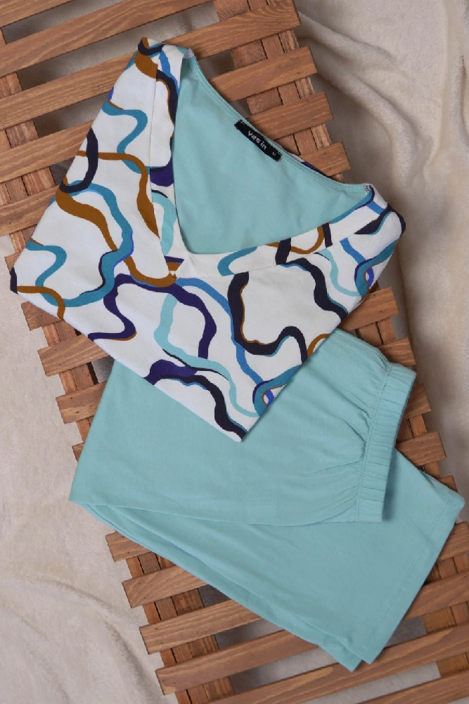 Pyjama satin turquoise à motifs fluides, idéal pour des soirées confortables en tenue d'intérieur tendance et élégante.