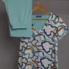 Pyjama satin turquoise avec un motif abstrait coloré, idéal pour une tenue d'intérieur confortable et élégante.