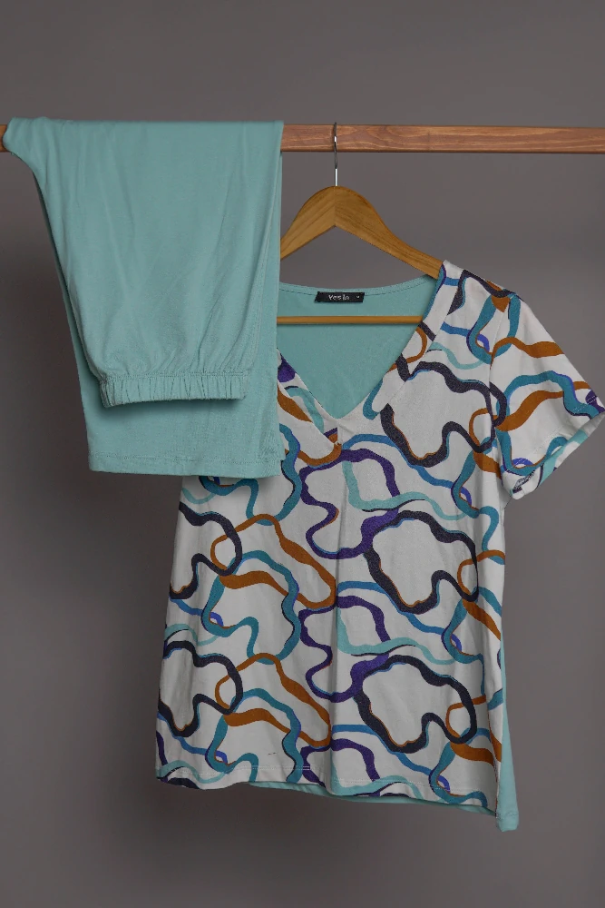 Pyjama satin turquoise avec un motif abstrait coloré, idéal pour une tenue d'intérieur confortable et élégante.