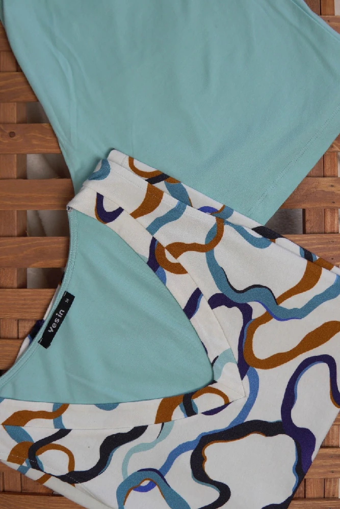 Coton-bleu-plat Pyjama satin bleu clair avec motifs colorés, parfait pour une tenue d'intérieur élégante et confortable.