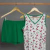 Pyjama doux en coton, haut blanc à motifs de cerises et short vert, idéal pour une tenue d'intérieur confortable et festive.