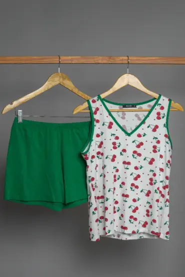 Pyjama doux en coton, haut blanc à motifs de cerises et short vert, idéal pour une tenue d'intérieur confortable et festive.