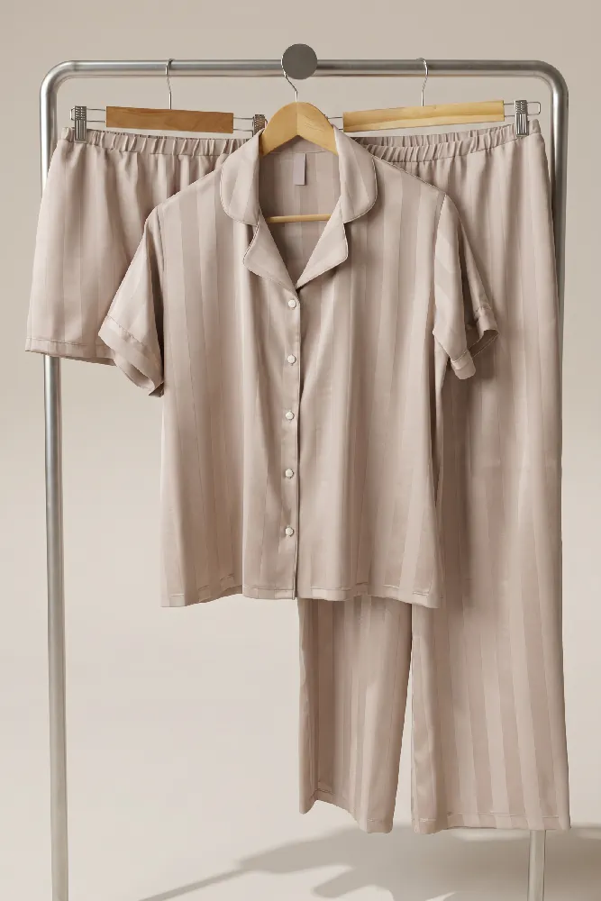 Ensemble pyjama en satin beige à rayures, confortable et élégant, parfait pour une tenue d'intérieur chic et luxueuse.