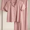 Ensemble de pyjama en satin rose, avec chemise à col et short élégant, idéal pour une tenue d'intérieur confortable.