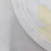 Pyjama satin blanc doux avec motifs floraux, idéal pour une tenue d'intérieur chic et confortable.