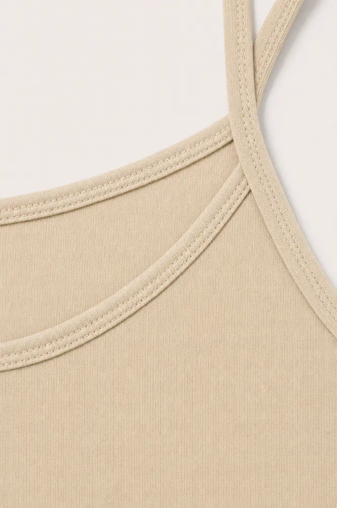 nude-beige-essential-spaghetti-strap-tank-top-close-up Pyjama satin beige en coton doux, idéal pour une tenue d'intérieur élégante et confortable pour vos nuits.