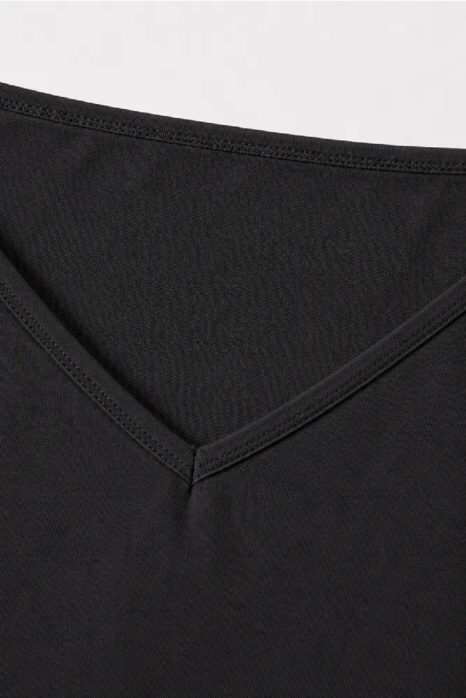 top-fines-bretelles-essential-col-black Pyjama satiné noir, doux et léger, idéal pour une tenue d'intérieur élégante et confortable.