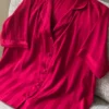 Pyjama satin rouge vif, au style moderne avec boutons, idéal pour une tenue d'intérieur élégante et confortable.