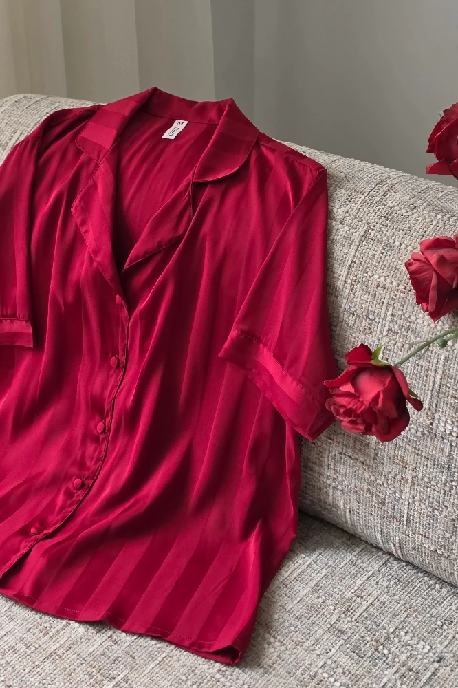 Pyjama satin rouge à rayures, haut léger et élégant, parfait pour une tenue d'intérieur chic et luxueuse.