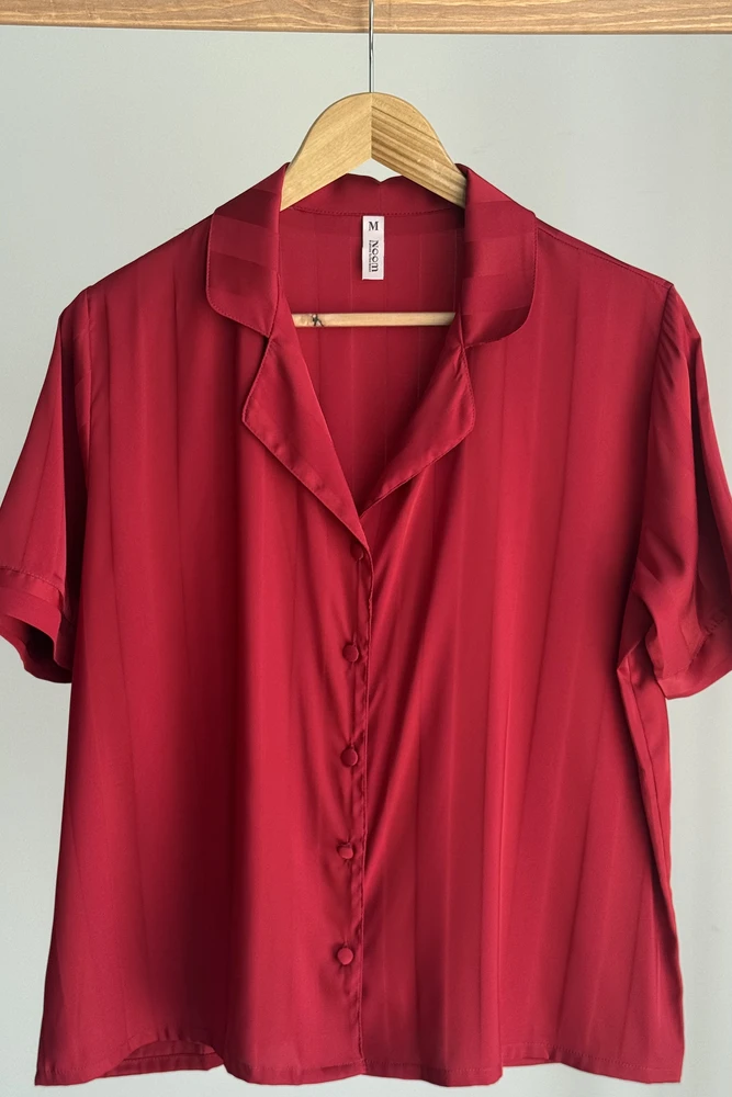 Pyjama satin rouge luxueux avec col, boutons et manches courtes, parfait pour une tenue d'intérieur élégante.