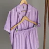 Pyjama en satin violet à rayures, léger et élégant, parfait pour une tenue d'intérieur confortable et stylée.