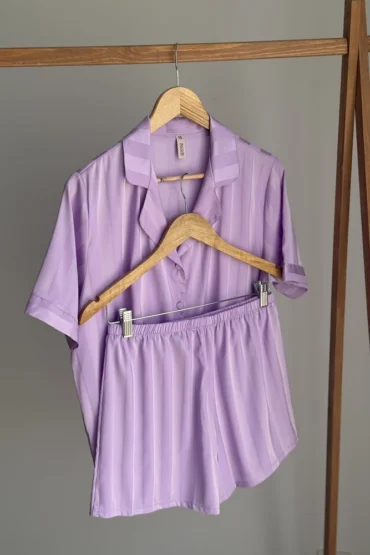 Pyjama en satin violet à rayures, léger et élégant, parfait pour une tenue d'intérieur confortable et stylée.
