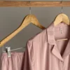 Pyjama satin rose clair, doux et élégant, idéal pour des nuits confortables en tant que tenue d'intérieur raffinée.