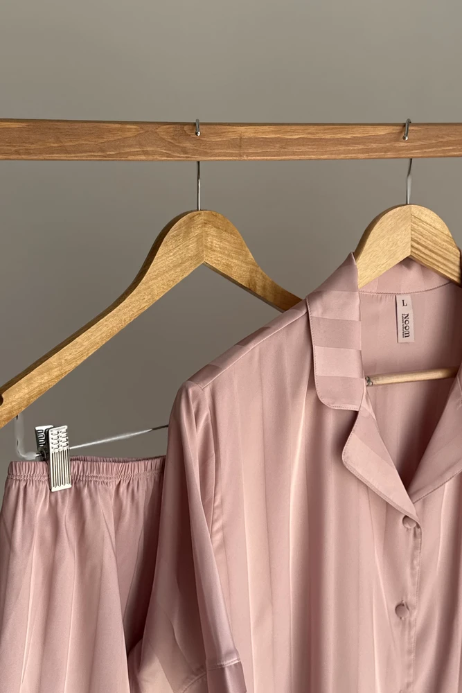 Pyjama satin rose clair, doux et élégant, idéal pour des nuits confortables en tant que tenue d'intérieur raffinée.