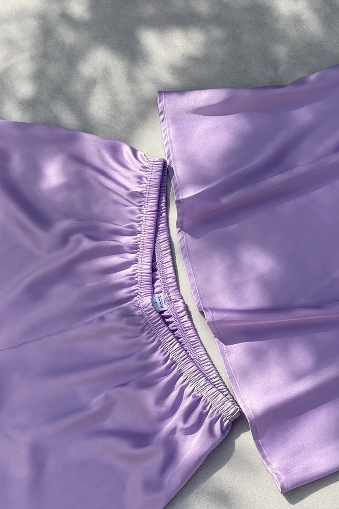 Ensemble de pyjama satin lavande, élégant et doux, parfait pour une tenue d'intérieur confortable et chic.