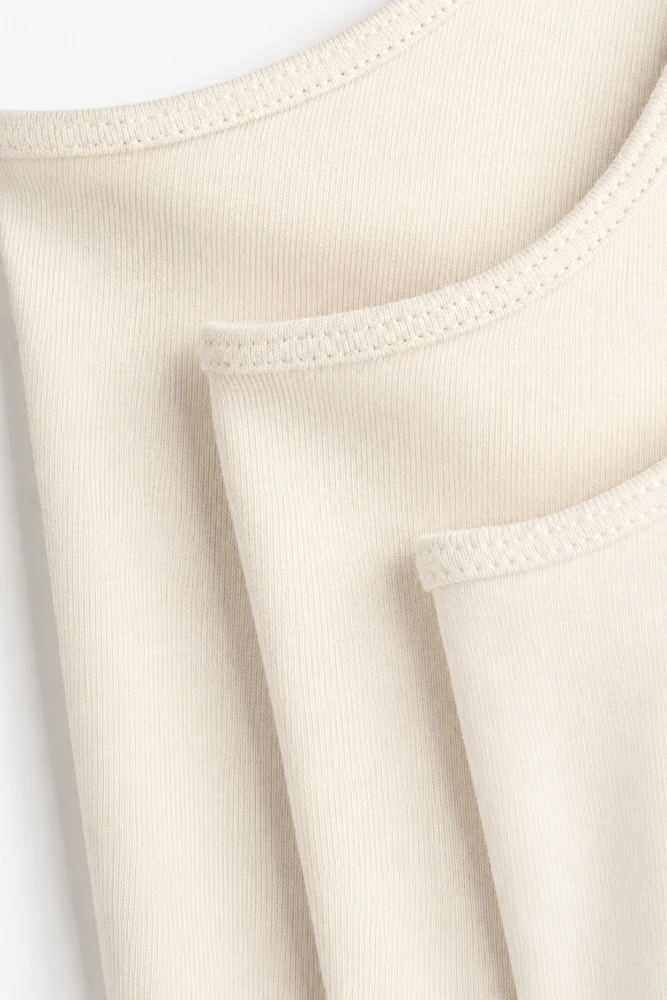 Pyjama satin beige doux et confortable, idéal pour une tenue d'intérieur élégante et relaxante.