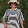 noom-green-stripe-lounge-tee-oversized-fullbody T-shirt rayé en coton doux, idéal comme tenue d'intérieur, associé à un pantalon blanc pour un look décontracté.