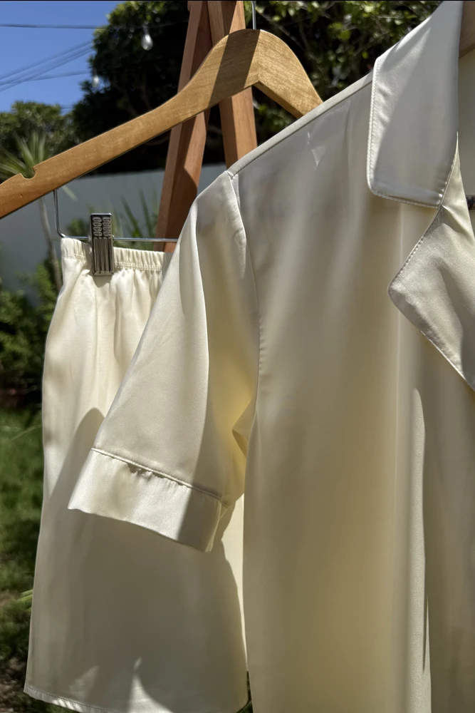 Ensemble pyjama en satin écru, à manches courtes, idéal en tenue d'intérieur pour des nuits luxueuses et confortables.