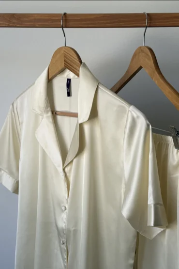 Pyjama satin élégant en ivoire, idéal pour une tenue d'intérieur luxueuse et confortable, avec un style classique et raffiné.