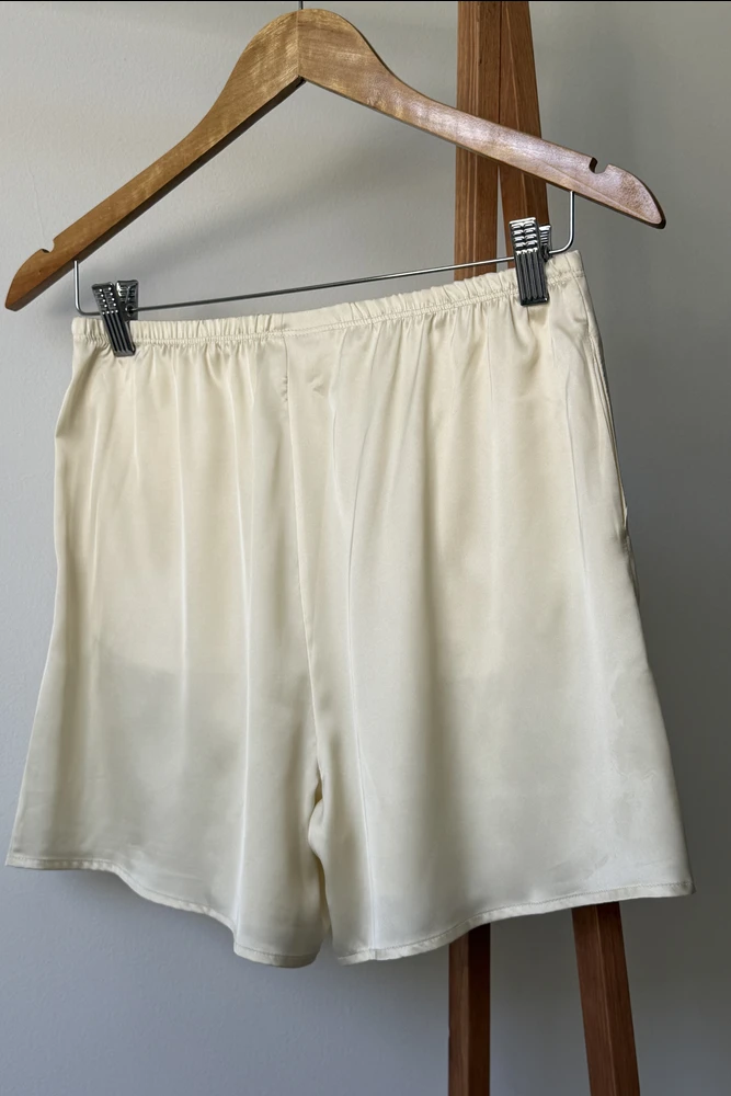 Shorts de pyjama en satin crème, doux et confortables, parfaits pour une tenue d'intérieur élégante et relaxante.