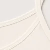 Pyjama satin beige doux avec bretelles fines, parfait pour une tenue d'intérieur élégante et confortable.