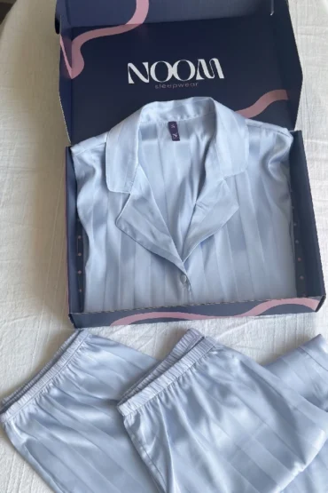 Pyjama satin bleu clair à rayures, élégant et confortable, idéal pour des soirées en détente à la maison.
