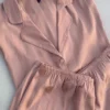 Pyjama satin rose délicat, tissu léger et doux, idéal pour une tenue d'intérieur élégante et confortable.
