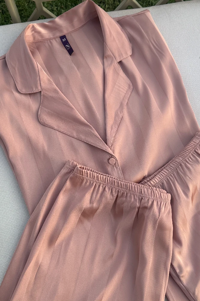 Pyjama satin rose délicat, tissu léger et doux, idéal pour une tenue d'intérieur élégante et confortable.