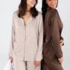 Ensemble de pyjama satiné, élégant et confortable, en couleur beige et chocolat, parfait pour une tenue d'intérieur luxueuse.